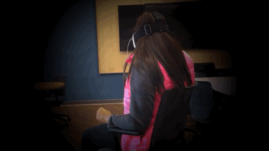 WVU Reed College of Media student experiences VR app "Sisters" wearing headphones and a Zeiss VR ONE headset.