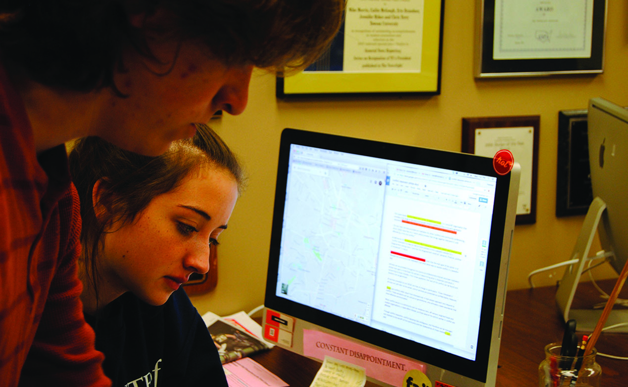 Two students compare an editing assignment with a Google map during a fact-checking exercise.