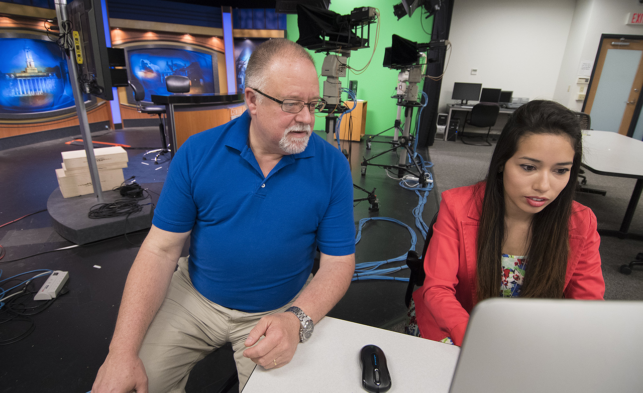 Senior lecturer Curt Chandler works with Lesly Salazar on a Verse presentation in the digital newsroom on the edge of the Centre County Report set. They are experimenting with Verse to create a new form of interactive newscast — a digicast — that allows viewers to quickly move between a tightly edited news summary and fully produced video stories. (Photo by Cameron Hart / Bellisario College of Communications | Penn State University)